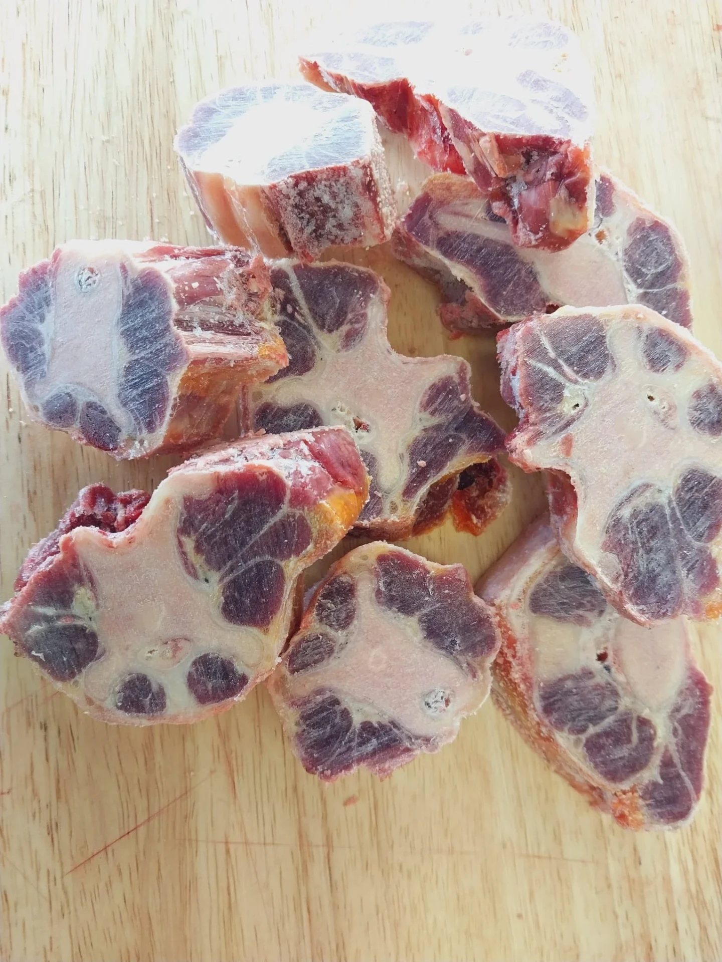 Cut halal beef oxtail pieces on a wooden cutting board