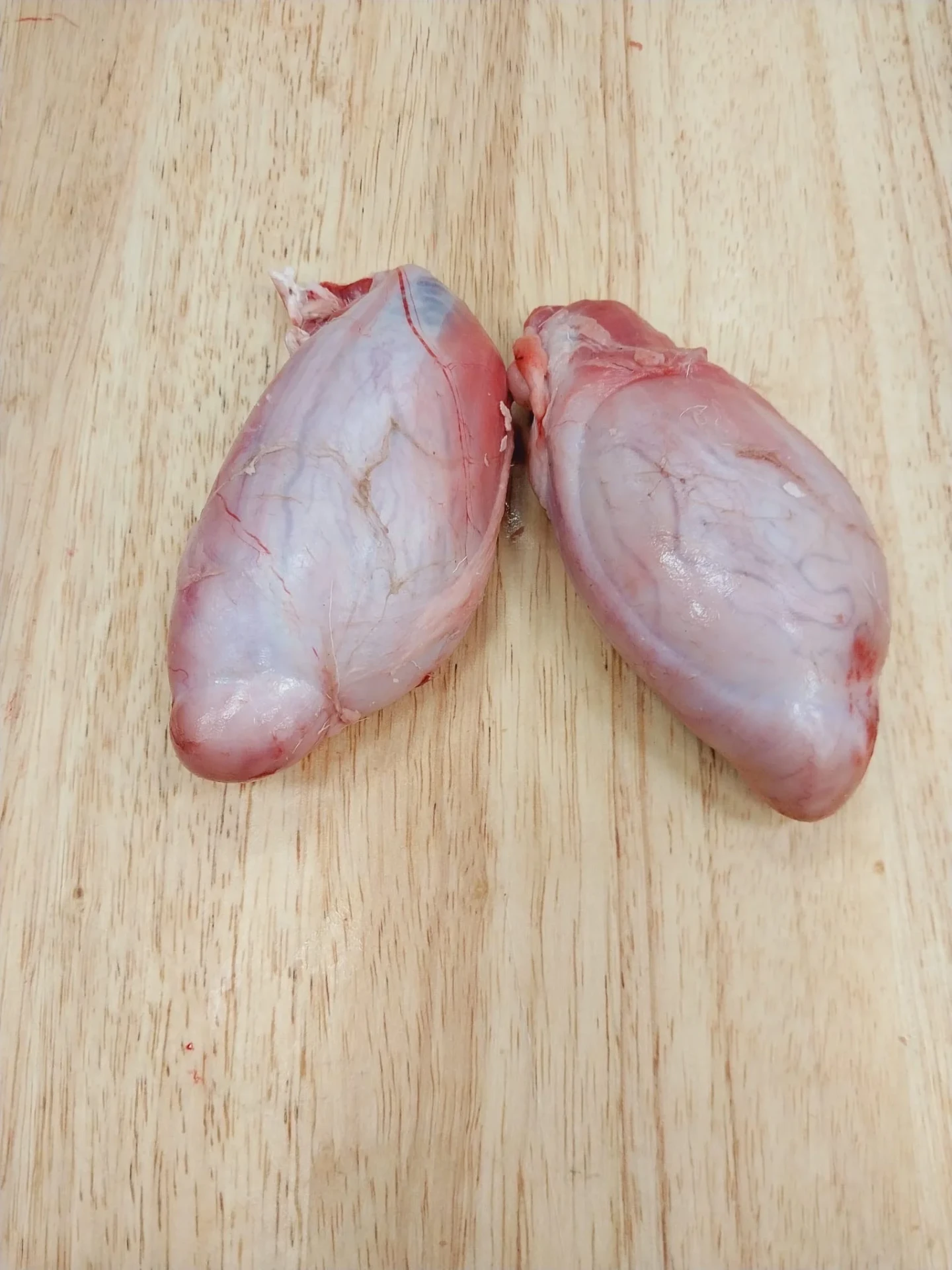 Fresh halal goat balls on a wooden cutting board