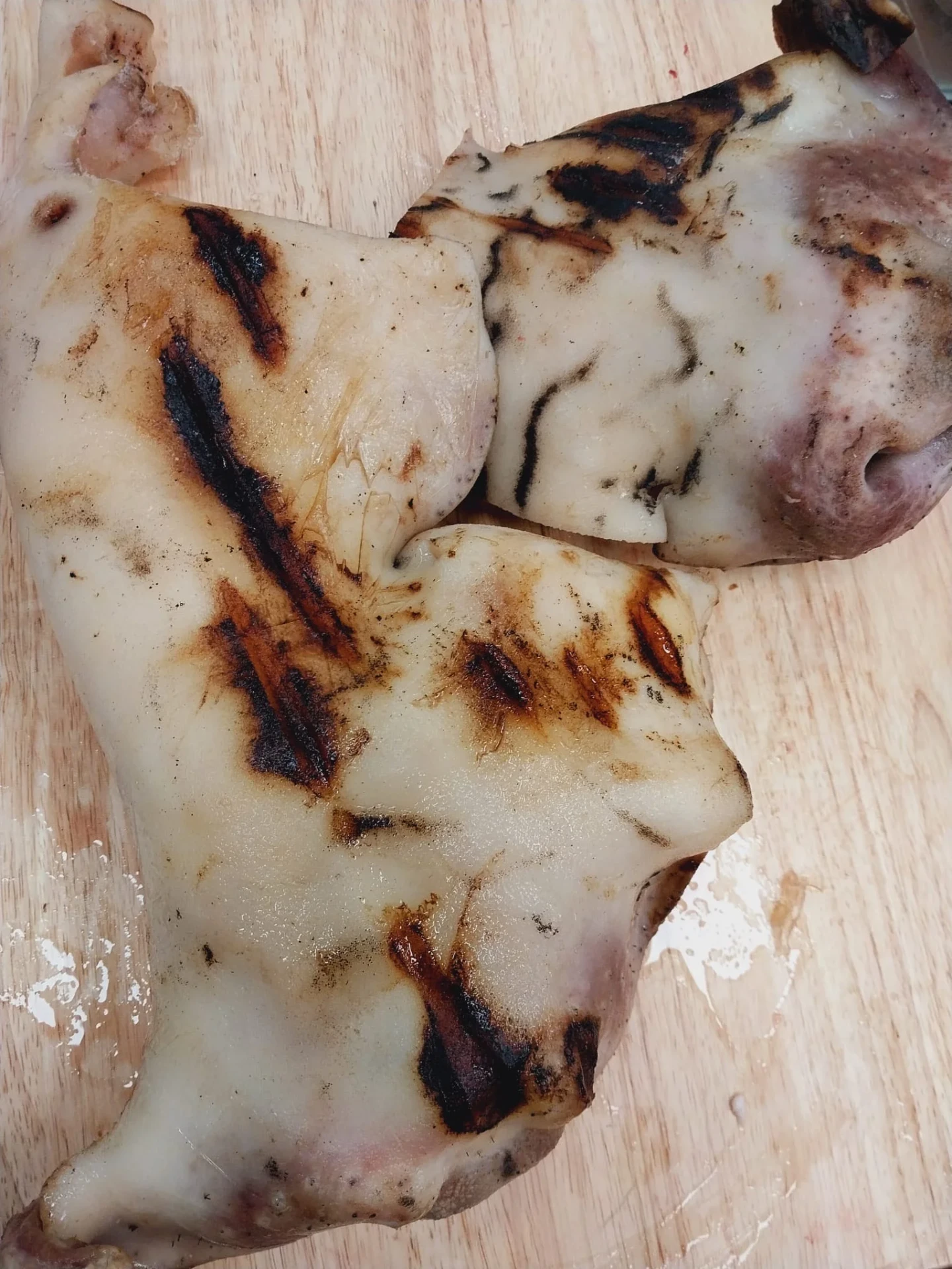 Singed brown halal beef skin pieces on a wooden board